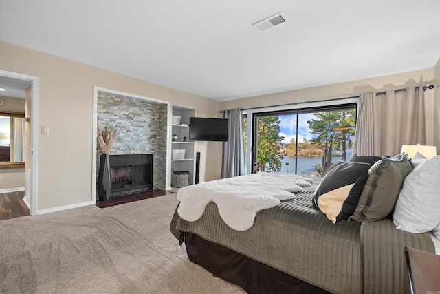 bedroom with dark hardwood / wood-style floors, access to exterior, and a fireplace