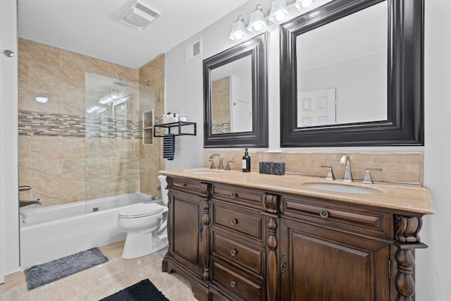 full bathroom featuring vanity, tile patterned floors, tiled shower / bath combo, toilet, and tasteful backsplash