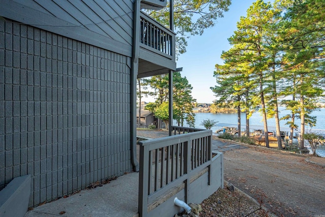 view of property exterior featuring a water view and a balcony