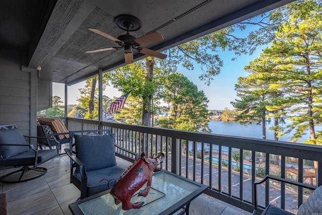 wooden terrace with a water view and ceiling fan