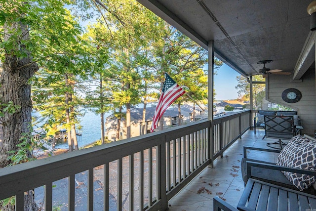 balcony with ceiling fan and a water view