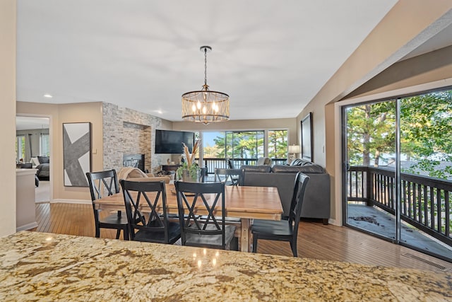 dining area with hardwood / wood-style floors and an inviting chandelier