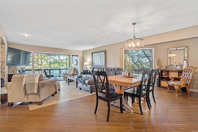 dining room with light hardwood / wood-style flooring and a notable chandelier