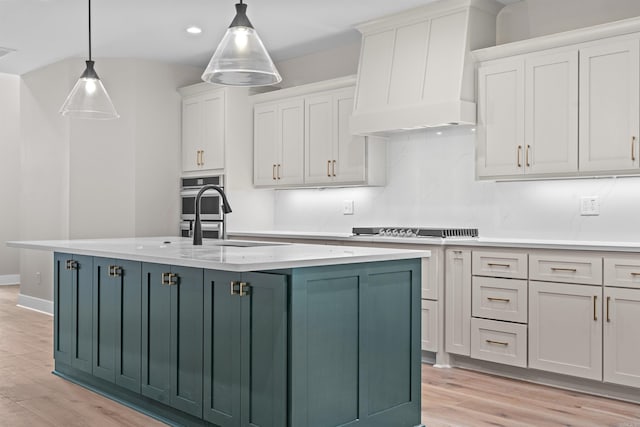 kitchen featuring light hardwood / wood-style flooring, white cabinets, pendant lighting, and custom range hood