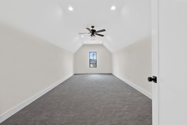 bonus room with dark colored carpet, vaulted ceiling, and ceiling fan