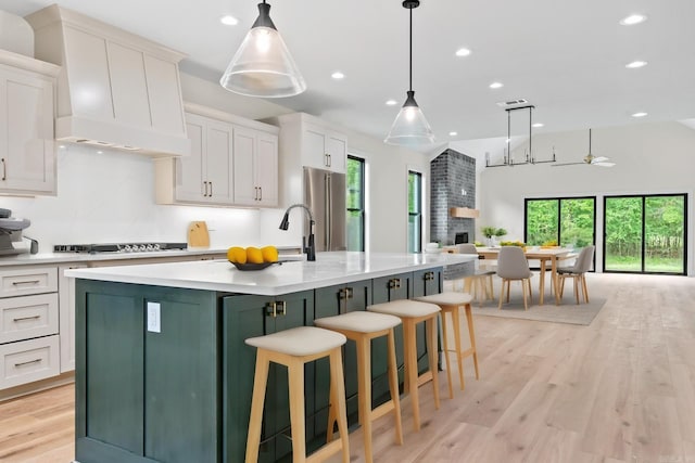 kitchen featuring custom range hood, white cabinetry, and a large island