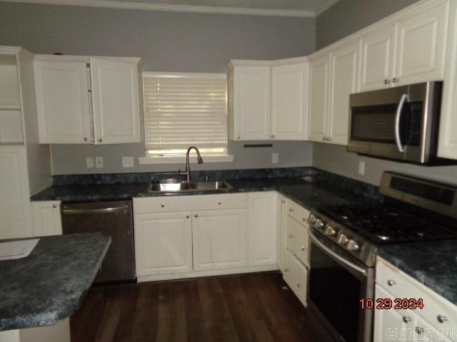 kitchen with sink, crown molding, dark hardwood / wood-style floors, white cabinetry, and stainless steel appliances