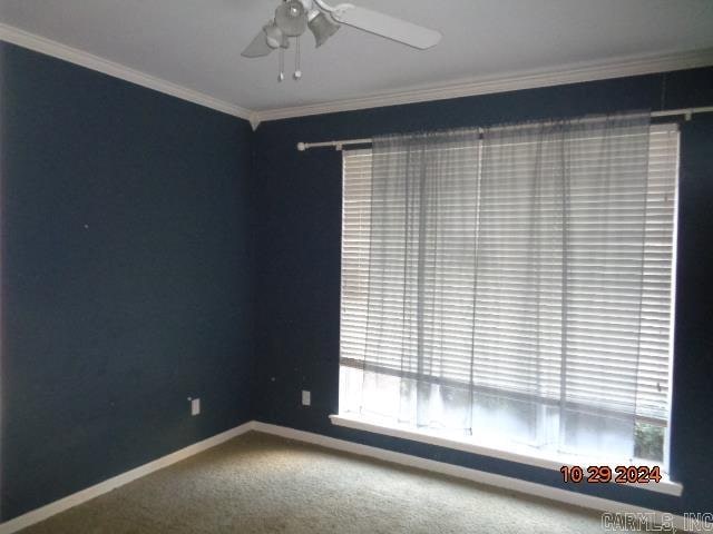 carpeted empty room with ceiling fan and ornamental molding