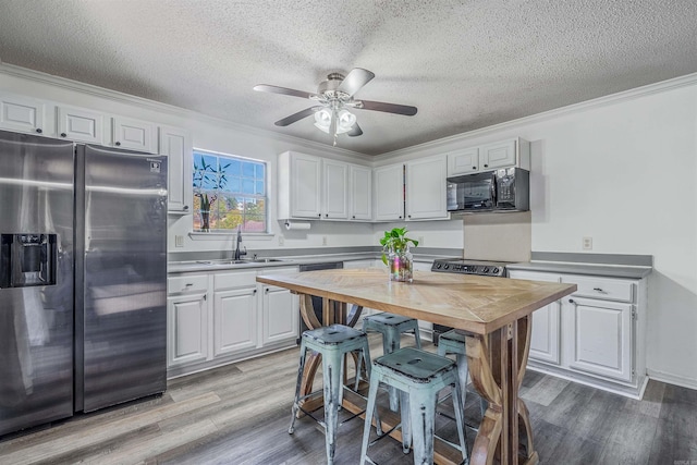 kitchen featuring light wood-type flooring, white cabinetry, and stainless steel appliances