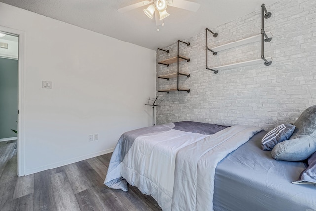 bedroom with a textured ceiling, ceiling fan, and dark wood-type flooring