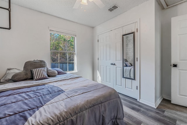 bedroom featuring hardwood / wood-style floors, ceiling fan, a textured ceiling, and a closet