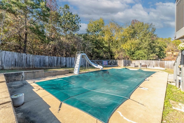 view of pool featuring a patio area and a water slide