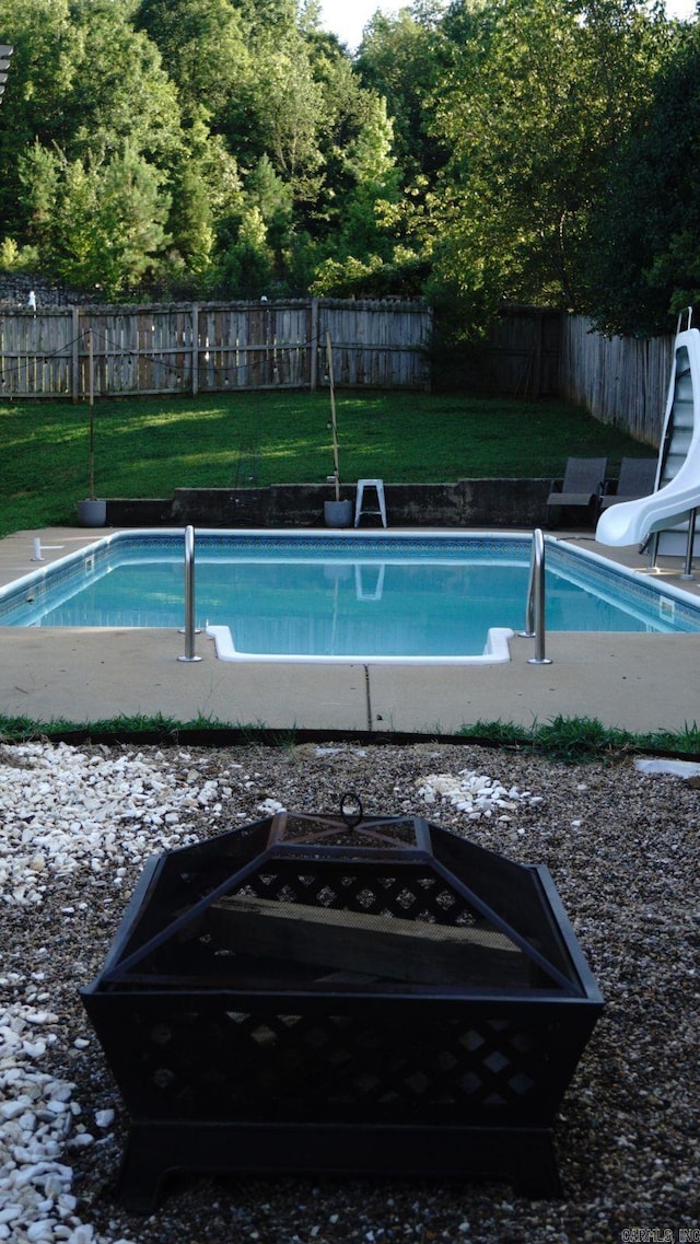 view of pool with a lawn and a water slide