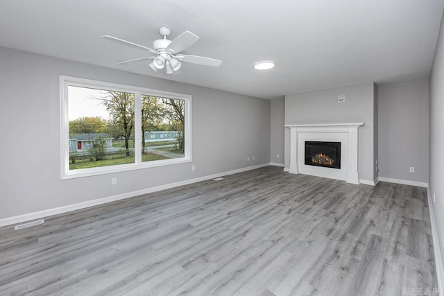 unfurnished living room with ceiling fan and light wood-type flooring