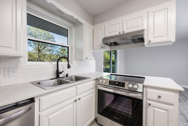 kitchen with white cabinets, decorative backsplash, sink, and stainless steel appliances