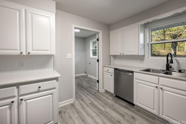 kitchen with dishwasher, sink, tasteful backsplash, light hardwood / wood-style floors, and white cabinetry