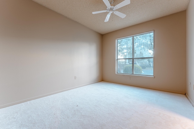 carpeted spare room featuring vaulted ceiling, ceiling fan, and a textured ceiling