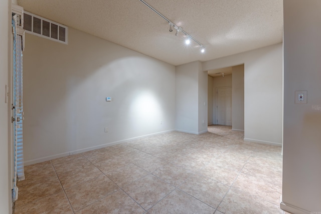 unfurnished room with light tile patterned floors and a textured ceiling