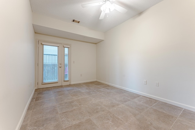 tiled empty room with a textured ceiling and ceiling fan