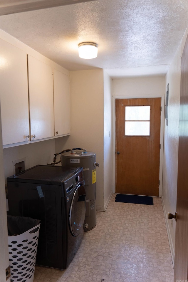 washroom featuring electric water heater, cabinets, a textured ceiling, and washer / dryer