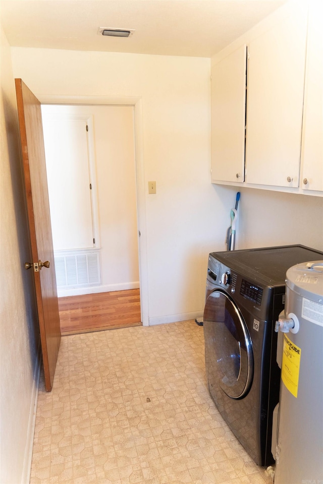 clothes washing area with cabinets, electric water heater, washer / clothes dryer, and light hardwood / wood-style floors