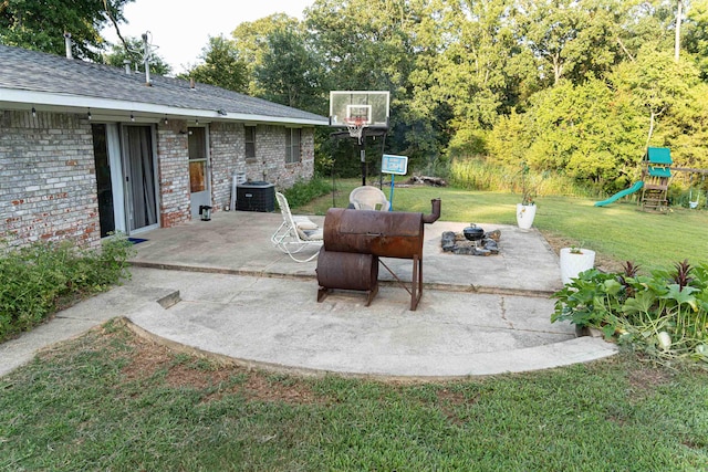 view of patio / terrace with a playground, an outdoor fire pit, and central air condition unit