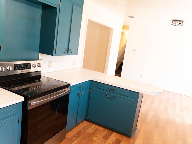 kitchen with kitchen peninsula, light hardwood / wood-style flooring, blue cabinets, and stainless steel range with electric cooktop