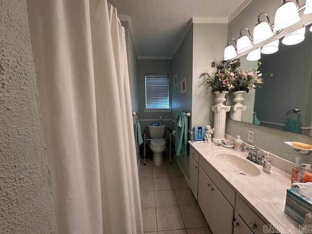 bathroom with tile patterned floors, a textured ceiling, vanity, crown molding, and toilet