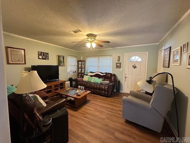 living room with crown molding, hardwood / wood-style floors, ceiling fan, and a textured ceiling