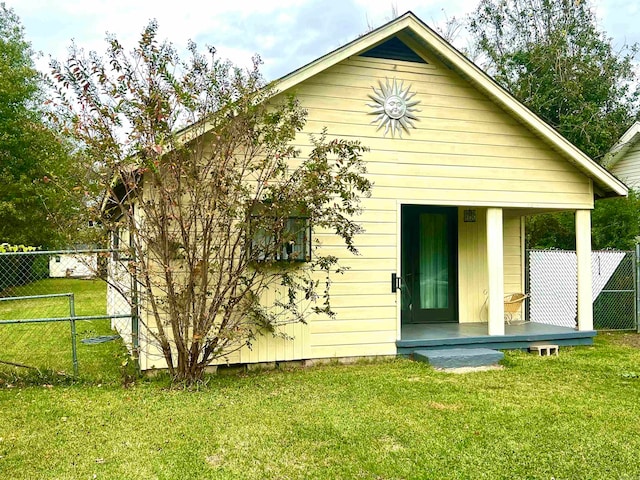 back of property featuring an outbuilding and a yard