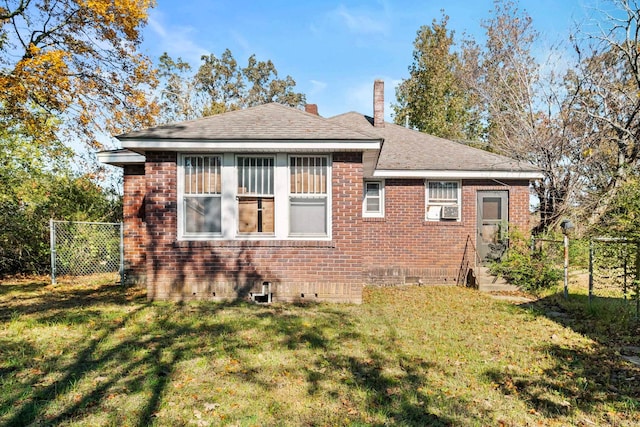 rear view of property with cooling unit and a yard