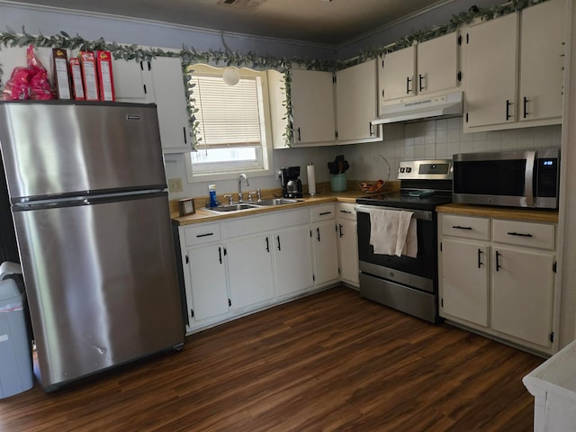 kitchen with white cabinets, sink, dark hardwood / wood-style floors, ornamental molding, and stainless steel appliances