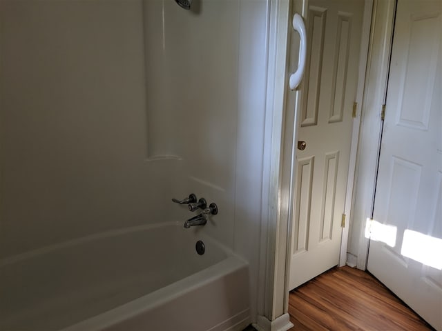 bathroom featuring hardwood / wood-style floors and  shower combination