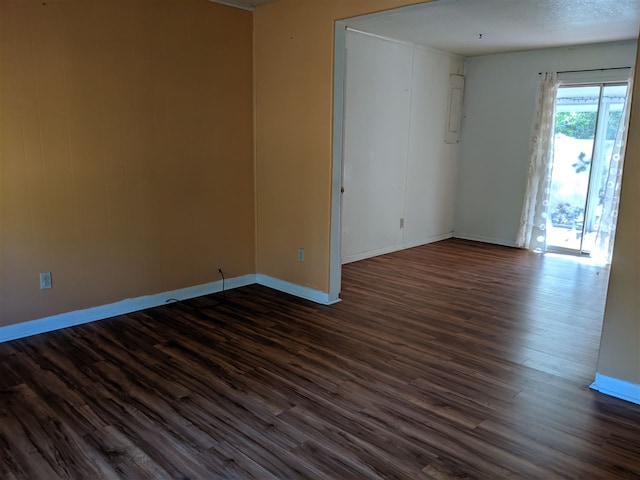 unfurnished room featuring a textured ceiling and dark hardwood / wood-style flooring