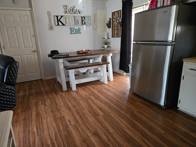 kitchen with white cabinets, dark wood-type flooring, and stainless steel refrigerator