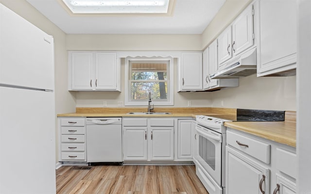 kitchen with sink, white appliances, white cabinetry, and light hardwood / wood-style floors