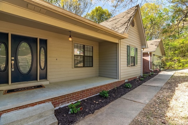 view of exterior entry featuring covered porch