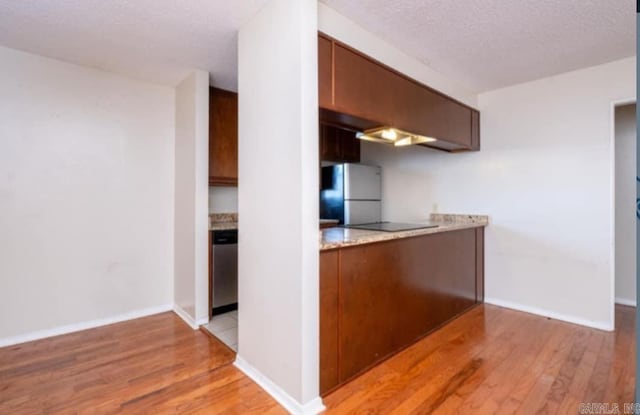 kitchen with stainless steel dishwasher, black electric cooktop, light hardwood / wood-style flooring, and fridge