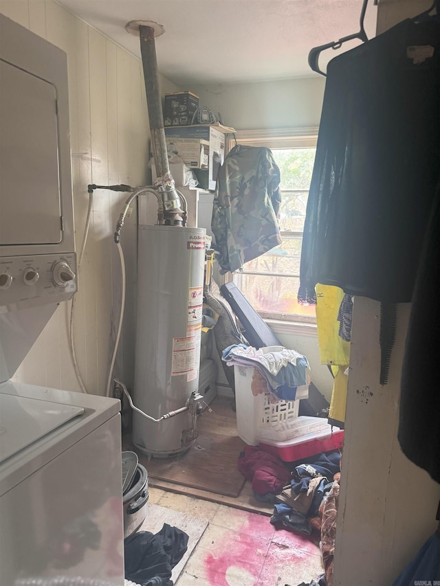 utilities with gas water heater and stacked washer and clothes dryer