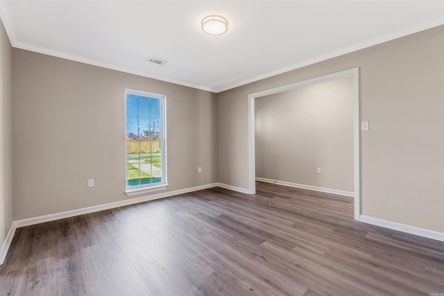 spare room featuring wood-type flooring and ornamental molding