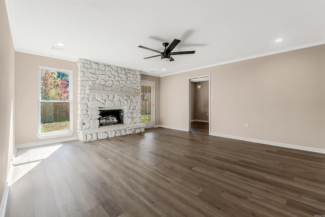 unfurnished living room featuring a fireplace, crown molding, dark hardwood / wood-style flooring, and ceiling fan