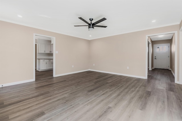 spare room featuring light wood-type flooring, ceiling fan, and ornamental molding