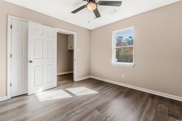 unfurnished bedroom with wood-type flooring, a closet, and ceiling fan