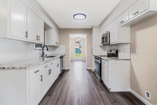 kitchen featuring white cabinets, sink, light stone counters, dark hardwood / wood-style flooring, and stainless steel appliances