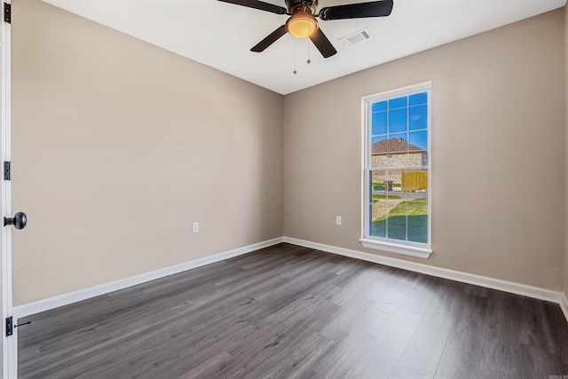 spare room featuring ceiling fan and dark wood-type flooring