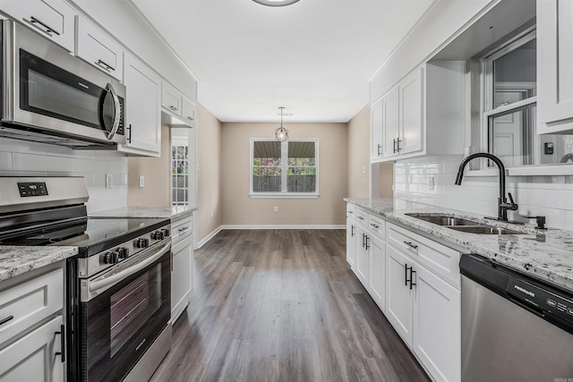 kitchen with white cabinetry, sink, stainless steel appliances, dark hardwood / wood-style floors, and pendant lighting