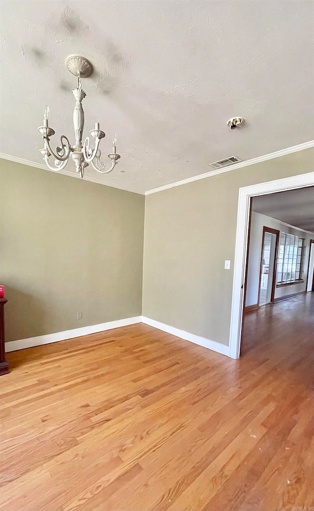 unfurnished room featuring crown molding, light hardwood / wood-style flooring, a chandelier, and a textured ceiling