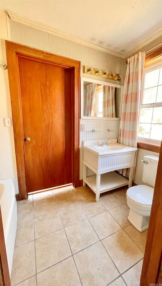 bathroom with tile patterned floors, vanity, toilet, and a tub to relax in