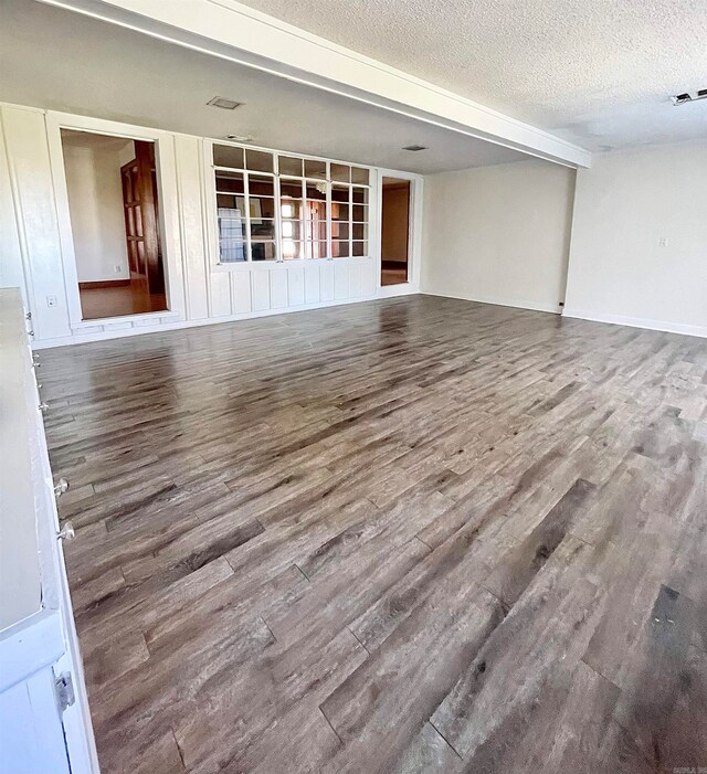 empty room with hardwood / wood-style floors and a textured ceiling