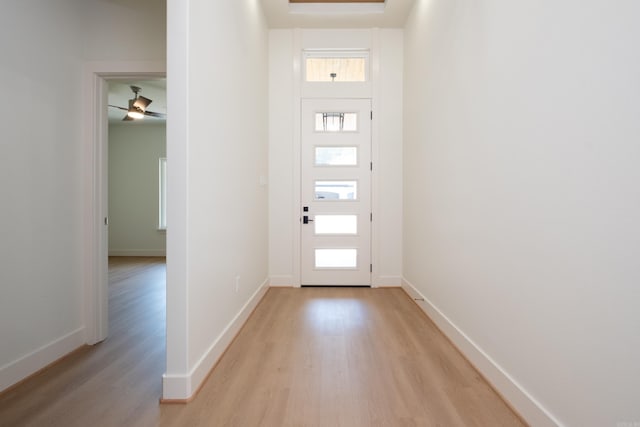 foyer entrance with ceiling fan and light hardwood / wood-style flooring